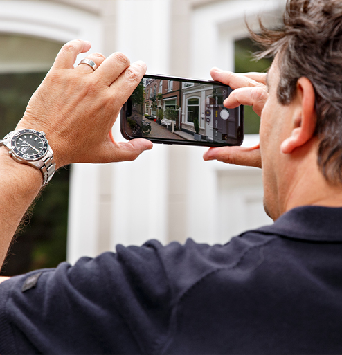 makelaar met camera in hand die een foto van een woning maakt