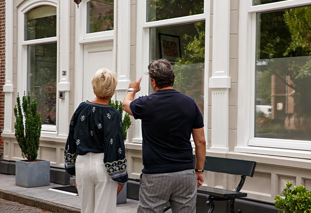 makelaar wijzend naar woning